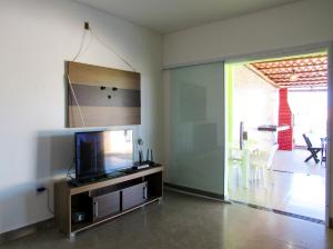 マラウにあるCasa Freitas com piscina em Taipu de Fora-Marau BAのリビングルーム(エンターテイメントセンター内の薄型テレビ付)