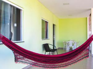 マラウにあるCasa Freitas com piscina em Taipu de Fora-Marau BAのリビングルーム(ハンモック、テーブル付)