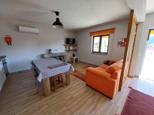 uma sala de estar com uma mesa e um sofá em Casa do Pátio em Sabugueiro