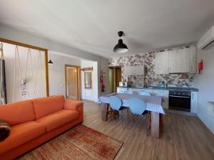 sala de estar con sofá naranja y mesa en Casa do Pátio, en Sabugueiro