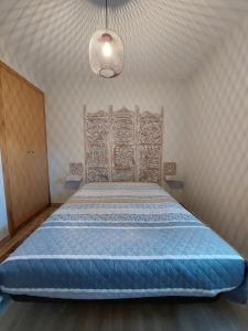 a bedroom with a large bed with a wooden headboard at Casa do Pátio in Sabugueiro