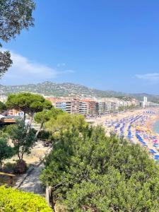 ein Strand mit vielen Sonnenschirmen und vielen Menschen in der Unterkunft Relax LUX apartment on Fenals beach in Lloret de Mar