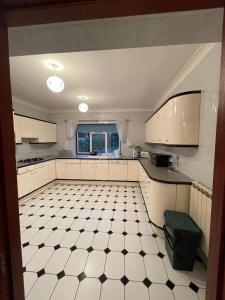 a kitchen with a black and white tiled floor at Charming 3 bed Bungalow in Bromley