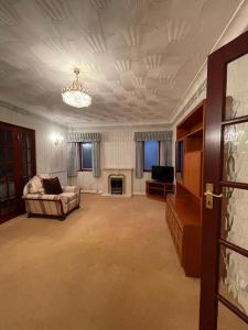 a large living room with a couch and a television at Charming 3 bed Bungalow in Bromley