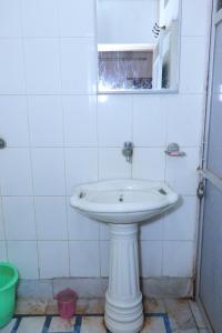uma casa de banho com um lavatório branco e um espelho. em Guest House Jamna Vilas em Bikaner