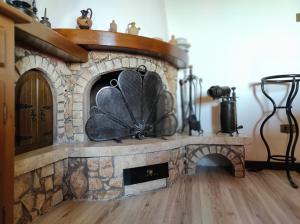 a stone fireplace with a fan on top of it at Anima d'Orcia - Ampio appartamento in pieno centro storico! in San Quirico dʼOrcia