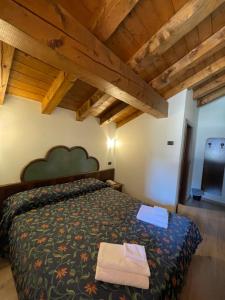 una camera con letto in una stanza con soffitti in legno di Hotel Quadrifoglio a Pinzolo