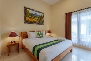 a bedroom with a bed and a window at BUBU CANGGU Guesthouse in Canggu +50 photos