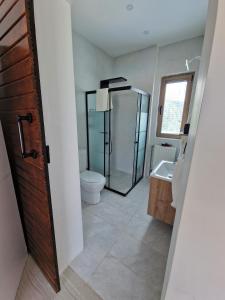 La salle de bains est pourvue d'une douche, de toilettes et d'un lavabo. dans l'établissement Bodega Butik Otel Şile, à Şile