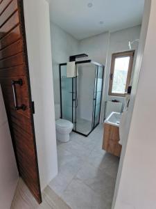 a bathroom with a shower and a toilet and a sink at Bodega Otel Şile in Şile