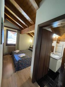 una piccola camera con letto e finestra di Hotel Quadrifoglio a Pinzolo