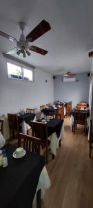 Hotel Quito في بوينس آيرس: غرفة طعام مع طاولات وكراسي ومروحة سقف