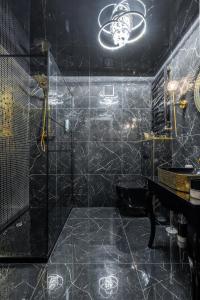 Baño negro con ducha y lavabo en BDSM BAST Apart Grey Manufaktura Centrum Miasta Legionów 18 Parking bezpłatny en Lodz