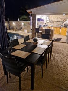 a wooden table and chairs in a room with a pool at Carrio appartement 2 chambres in Calpe