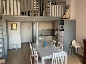 a kitchen and dining room with a table and chairs at Collioure, bel appartement de 40m2 avec balcon et parking in Collioure +20 photos