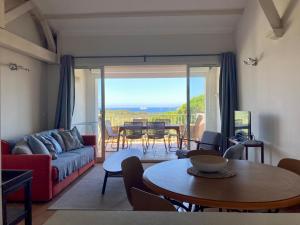 ein Wohnzimmer mit einem Sofa und einem Tisch in der Unterkunft Les Restanques 3120 vue mer 3 chambres in Grimaud