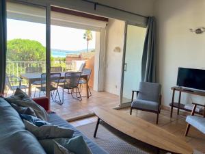 sala de estar con sofá y mesa en Les Restanques 3120 vue mer 3 chambres en Grimaud