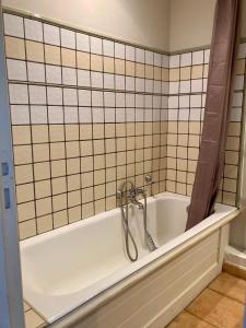 y baño con bañera y pared de azulejos. en Les Restanques 3120 vue mer 3 chambres, en Grimaud