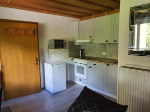 a kitchen with white cabinets and a white refrigerator at Landhaus Alexa in Eben im Pongau
