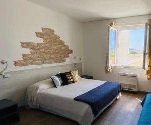 a bedroom with a bed and a brick wall at Fattoria il Duchesco in Alberese