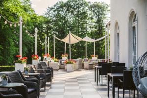 a patio with chairs and tables and a tent at Pałac Łebunia in Łebunia