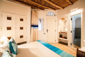 a bedroom with a large white bed in a room at Dar Liouba Hotel in Essaouira