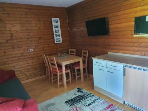 sala de estar con mesa y cocina con TV. en Landhaus Alexa, en Eben im Pongau