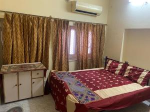 a bedroom with a bed and a window with curtains at Jamna vilas Home Stay in Bikaner