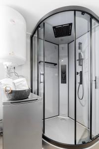 a shower with a glass door in a bathroom at Domek na Wodzie FM - Czarna perła in Mrągowo