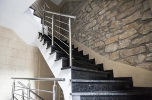 a staircase in a building with a stone wall at The Queen Luxury apartments - Villa Giorgia in Dudelange