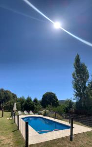 a fence around a swimming pool with a light above it at Cabañas La Pampita in Villa La Angostura