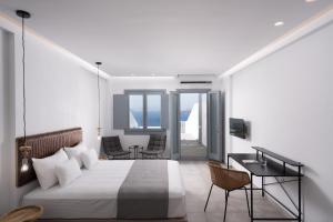 El Destino Suites في أكروتيري: غرفة نوم بسرير ومكتب وكراسي