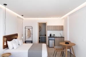 El Destino Suites في أكروتيري: غرفة نوم بسرير وطاولة ومطبخ
