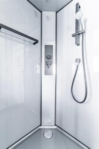 a shower in a bathroom with a glass door at Domek na Wodzie FM - Czarna perła in Mrągowo