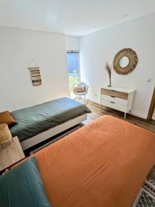 a bedroom with two beds and a couch and a mirror at Entre Pomares in Alcobaça