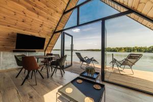 a room with a table and chairs and a large window at Domek na Wodzie FM - Czarna perła in Mrągowo