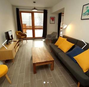 uma sala de estar com um sofá e uma mesa de centro em Deux Alpes - Résidence aux pieds des pistes -8 pers em Les Deux Alpes