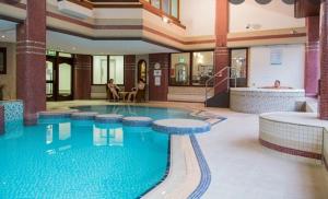 a large swimming pool in a large building at Woodside Cottage with free Spa access in Newby Bridge