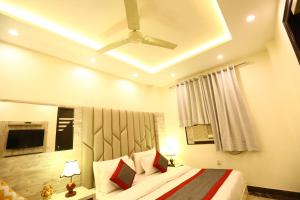 Schlafzimmer mit einem Bett und einem Deckenventilator in der Unterkunft Hotel Amrit Villa Karol Bagh New Delhi - Couple Friendly in Neu-Delhi