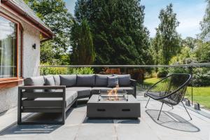 a patio with a couch and a fire pit at Loughrigg Cottage in Ambleside