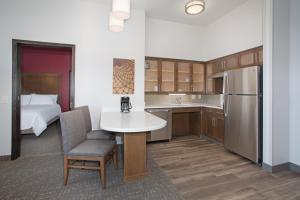 uma cozinha com uma mesa e uma cama num quarto em Staybridge Suites Rapid City - Rushmore, an IHG Hotel em Rapid City