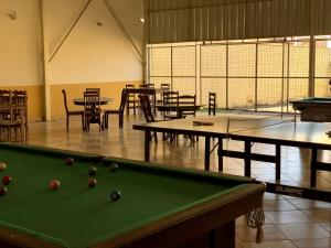 a room with a pool table and tables and chairs at Pousada Por do Sol in Quatis