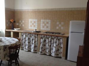 a kitchen with a counter and a refrigerator and a table at B&B La Rosa in Gioia dei Marsi +8 photos