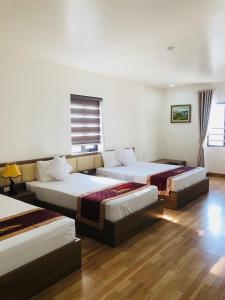 a hotel room with two beds and a window at Kim Ngan Ha Long Hotel in Ha Long