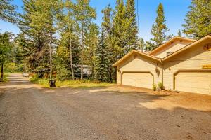 a house with a garage next to a dirt road at Retreat in McCall