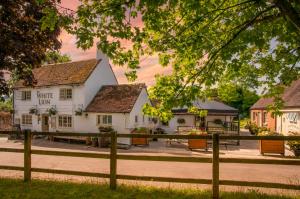 a white inn with a fence in front of it at The White Lion, Soberton in Soberton