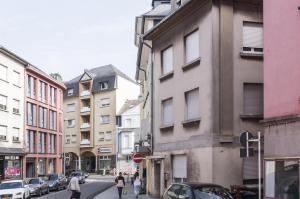 a group of people walking down a city street at The Queen Luxury apartments - Villa Giorgia in Dudelange
