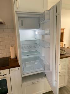 an empty refrigerator with its door open in a kitchen at Allegra Appenzell in Trogen