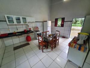 eine Küche mit Tisch und Stühlen in einem Zimmer in der Unterkunft Linda casa com banho natural em Guaramiranga in Guaramiranga
