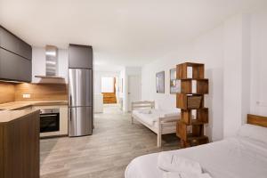 a kitchen and a living room with a bed in a room at TuApartamento Navarreria Loft in Pamplona